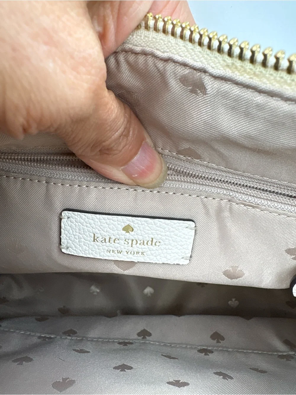 Kate Spade New York cream leather crossbody bag featuring a striped webbing Stra
